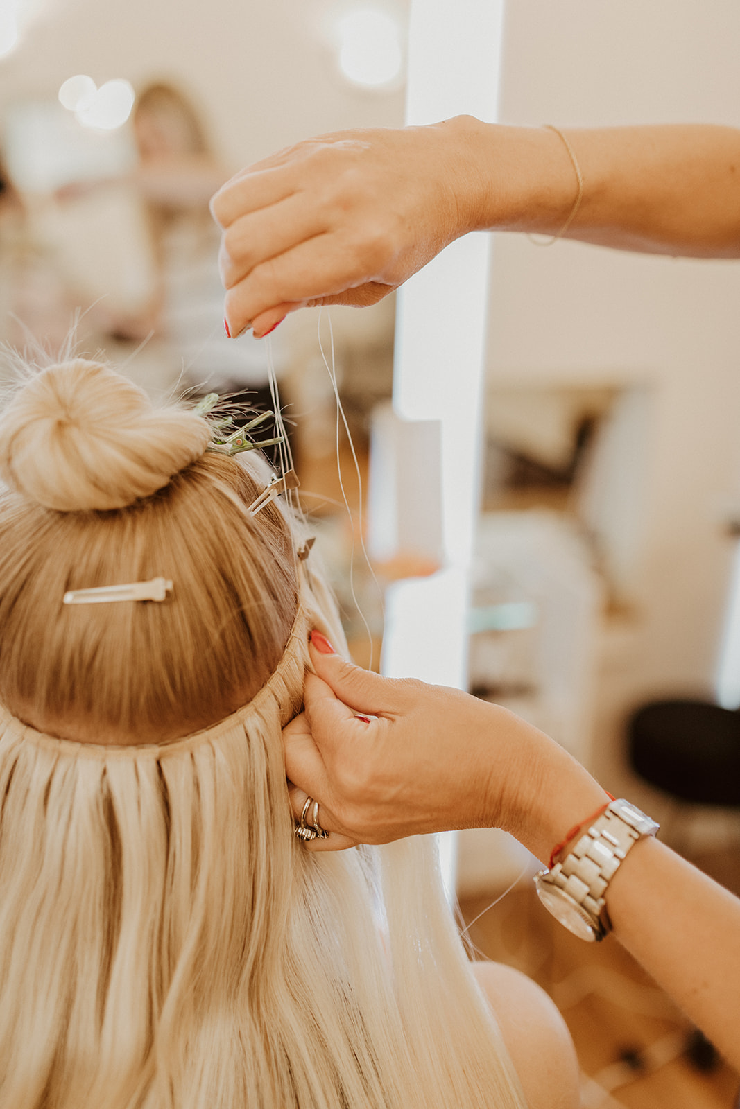 Hand-tied weft hair extensions being installed at Fluff Denver