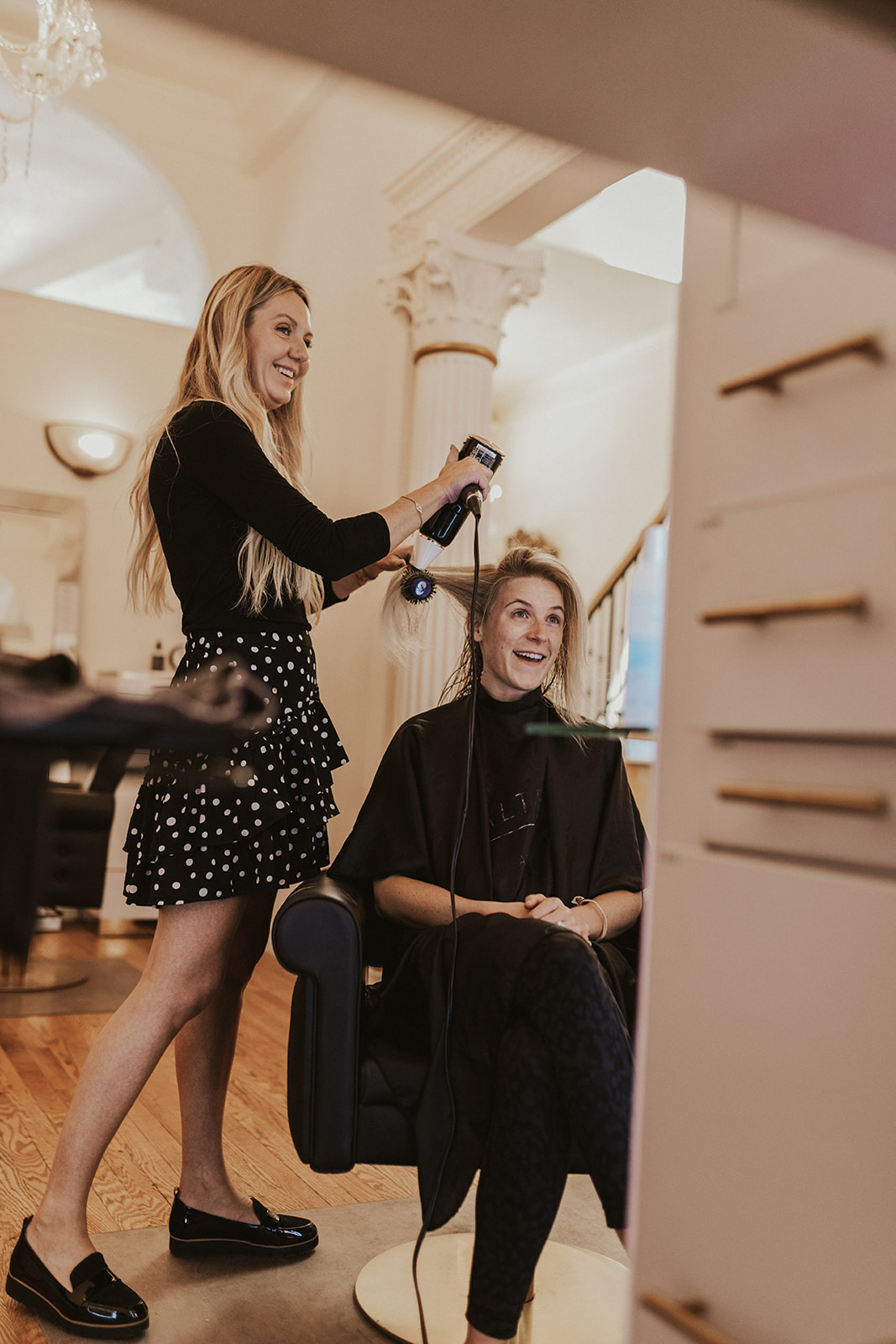 Stylist and client laughing during blowout at Fluff salon in LoDo Denver